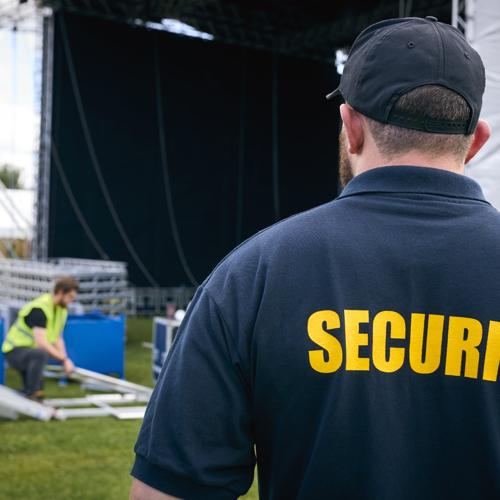 Security guard overseeing outdoor stage setup